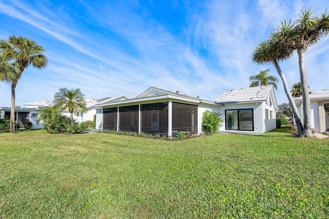 back of house with a sunroom and a lawn