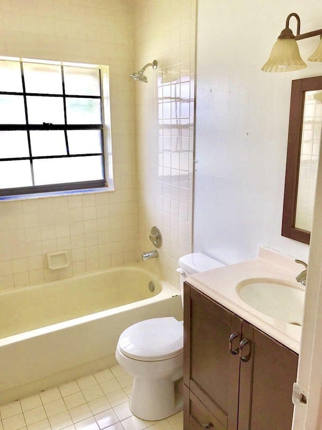 full bathroom featuring vanity, tile patterned flooring, tiled shower / bath combo, and toilet