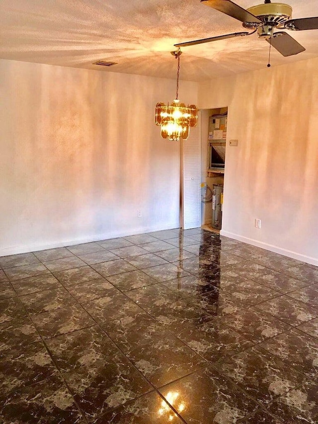 empty room featuring ceiling fan with notable chandelier and a textured ceiling