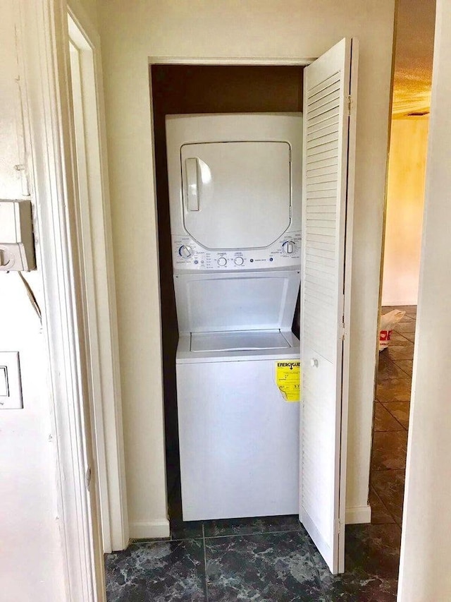 clothes washing area featuring stacked washer / dryer