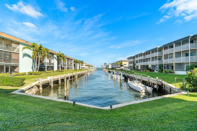 view of dock with a water view and a yard