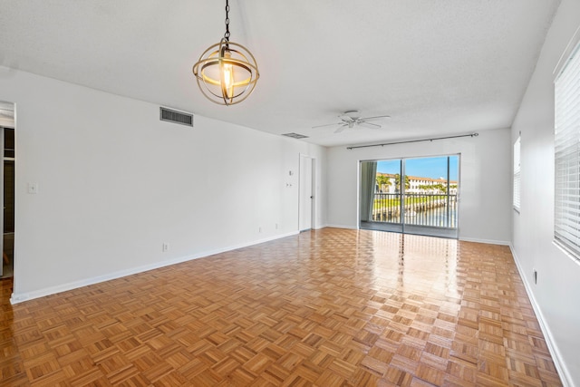 unfurnished room with ceiling fan, a textured ceiling, and light parquet floors