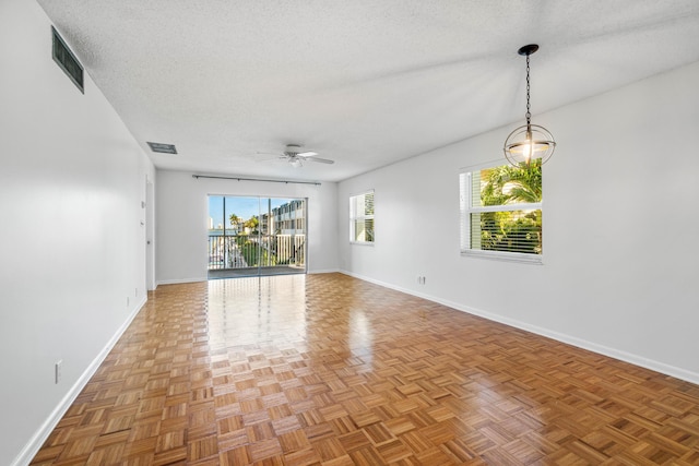 spare room with ceiling fan, parquet floors, and a textured ceiling