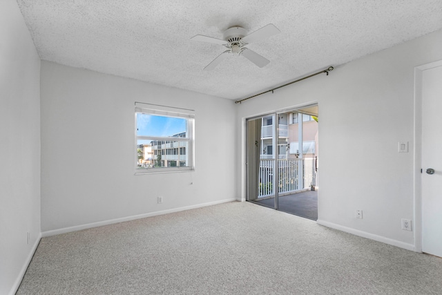 empty room featuring ceiling fan, carpet, and a textured ceiling