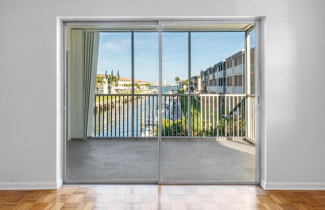 entryway featuring a water view and parquet flooring