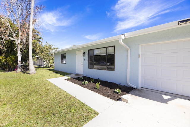 single story home featuring a garage, a front lawn, and stucco siding