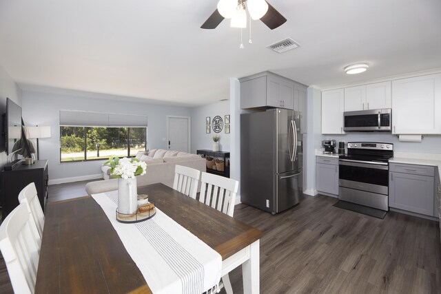 kitchen featuring stainless steel appliances, dark hardwood / wood-style floors, and gray cabinetry