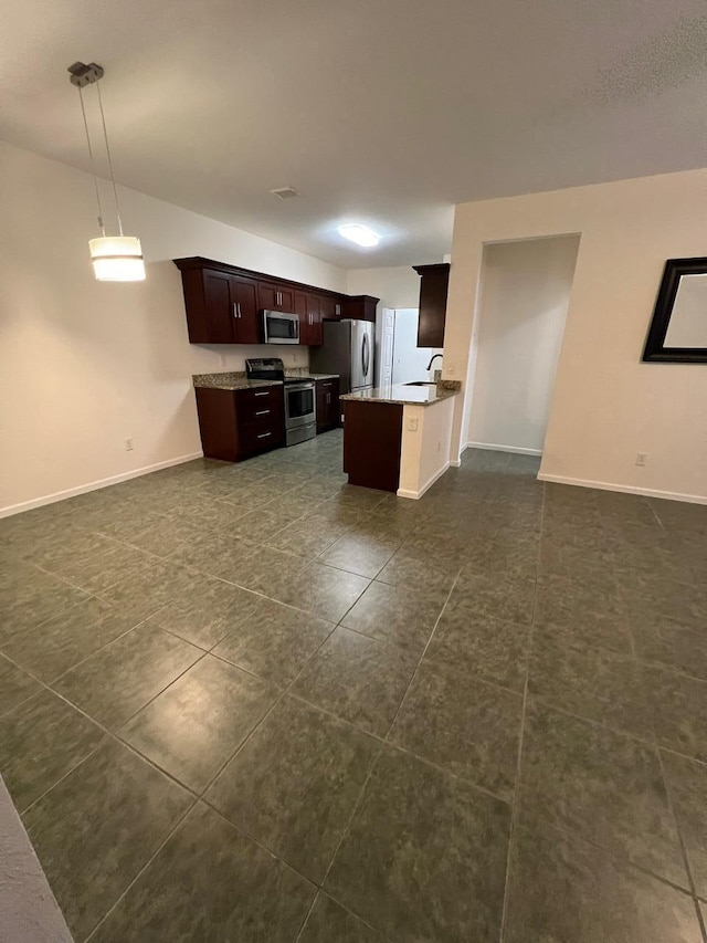 kitchen featuring a center island, dark brown cabinetry, hanging light fixtures, and appliances with stainless steel finishes