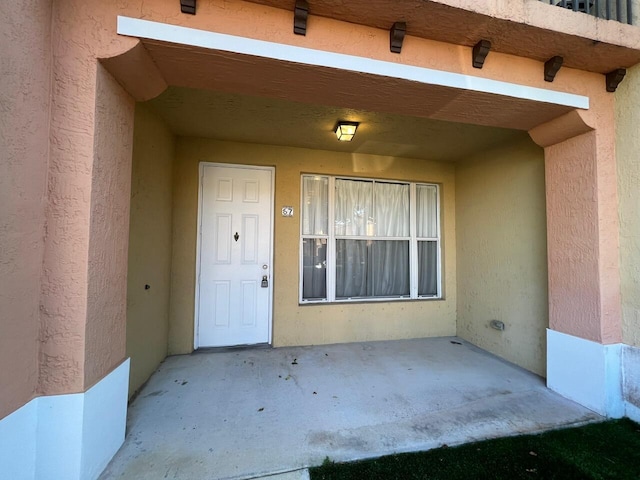 view of exterior entry featuring a patio area