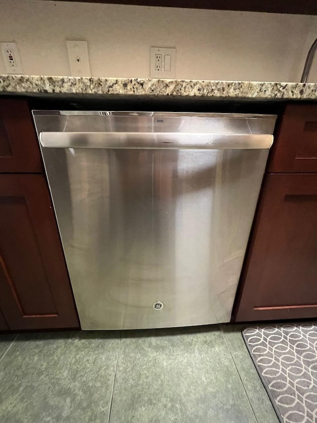 interior details featuring stainless steel dishwasher, stone counters, and dark brown cabinetry