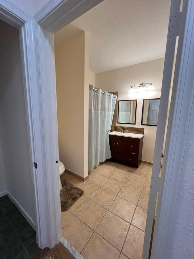 bathroom featuring toilet, tile patterned flooring, a shower with shower curtain, and vanity