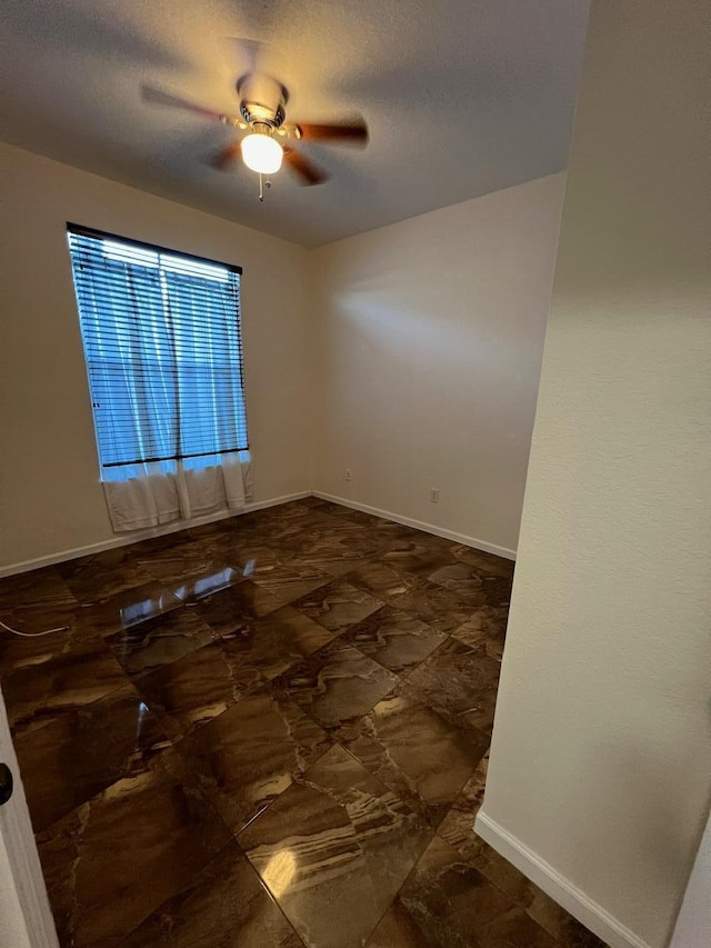 spare room with ceiling fan and a textured ceiling