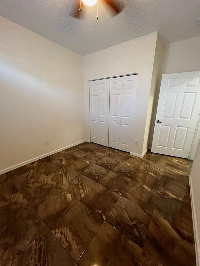 unfurnished bedroom featuring a textured ceiling, a closet, and ceiling fan