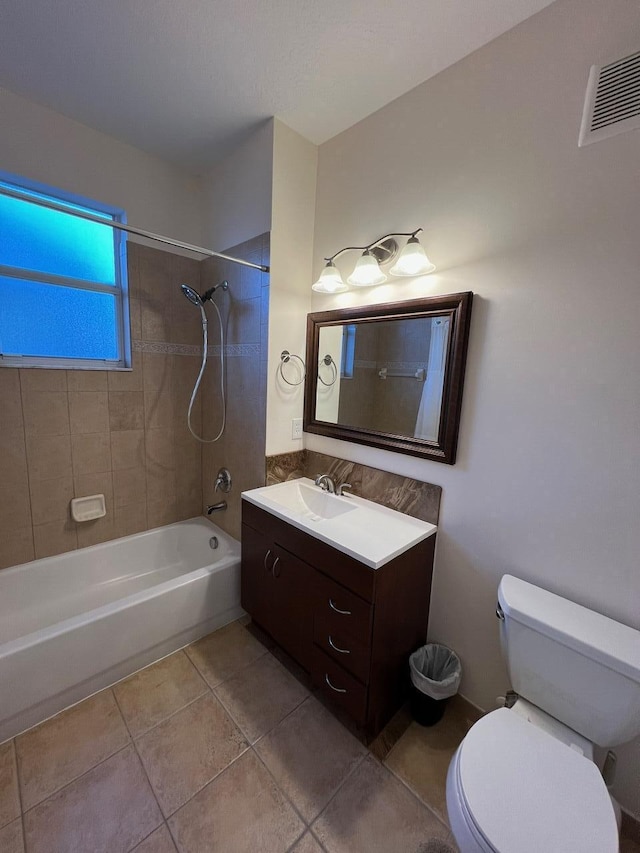 full bathroom with tiled shower / bath combo, vanity, toilet, and tile patterned flooring