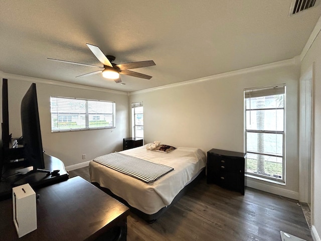 bedroom with multiple windows, ornamental molding, and ceiling fan