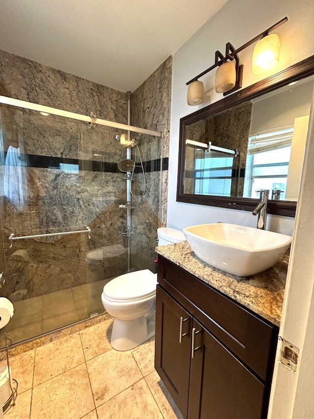 bathroom featuring vanity, toilet, and a shower with door