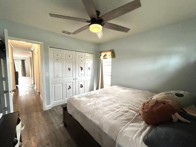 bedroom featuring ceiling fan, dark hardwood / wood-style flooring, and a closet