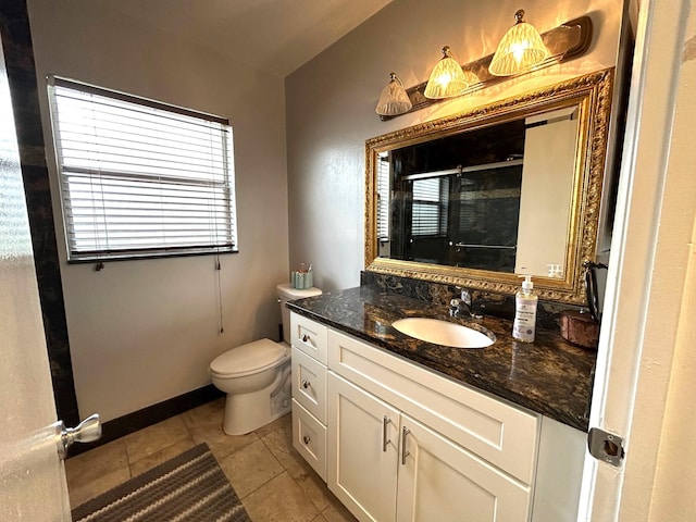 bathroom with toilet, vanity, tile patterned floors, and walk in shower