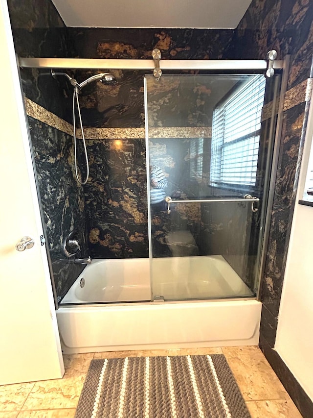 bathroom featuring tile patterned floors and shower / bath combination with glass door