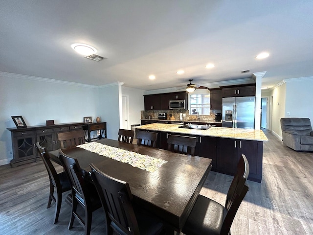 dining space featuring sink, ornamental molding, light hardwood / wood-style floors, and ceiling fan