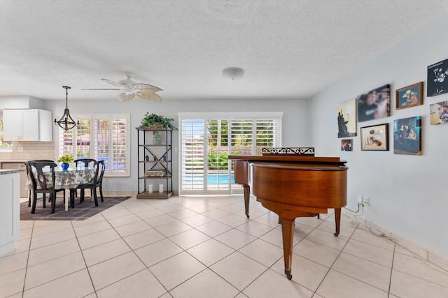 misc room featuring ceiling fan, a textured ceiling, and light tile patterned floors