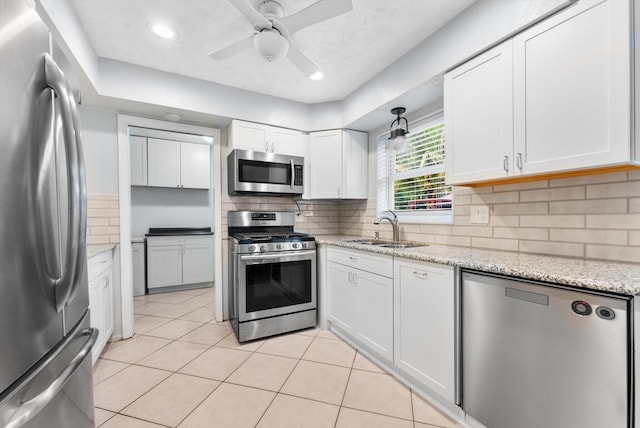 kitchen featuring backsplash, sink, white cabinets, and appliances with stainless steel finishes