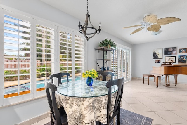 tiled dining room featuring ceiling fan with notable chandelier