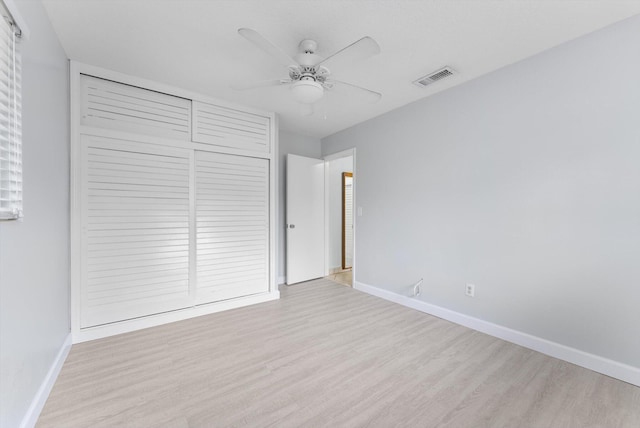 unfurnished bedroom featuring ceiling fan, light hardwood / wood-style floors, and a closet