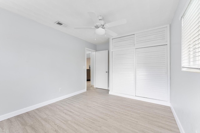 unfurnished bedroom with light hardwood / wood-style flooring, a closet, and ceiling fan