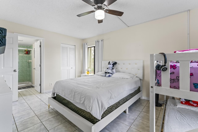 bedroom featuring ceiling fan, connected bathroom, a textured ceiling, and light tile patterned flooring