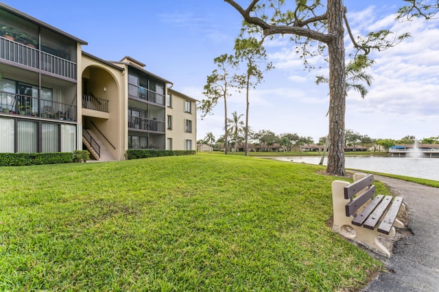 view of community featuring a water view and a yard