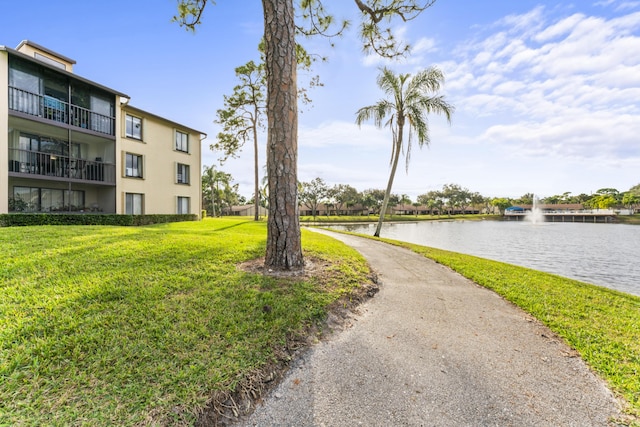 view of property's community with a yard and a water view