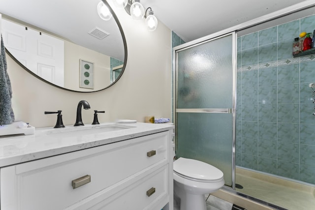 bathroom featuring vanity, toilet, and an enclosed shower