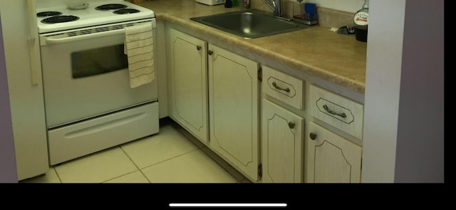 kitchen with cream cabinets, white electric range, sink, and light tile patterned floors