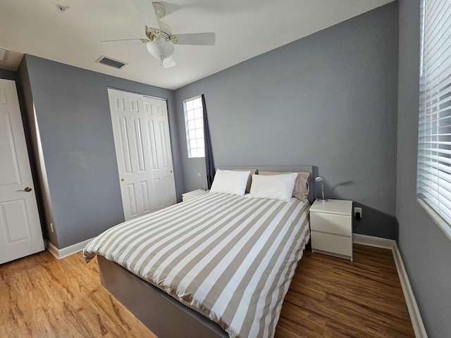 bedroom featuring ceiling fan, hardwood / wood-style floors, and a closet