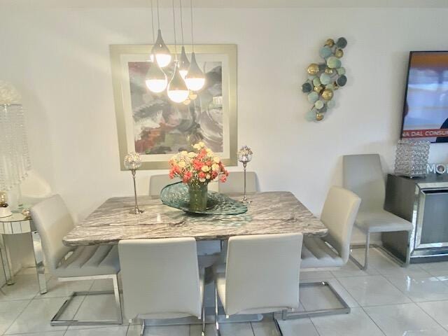 tiled dining area featuring a notable chandelier