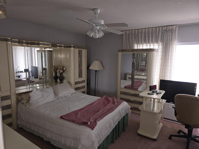 carpeted bedroom featuring ceiling fan and a textured ceiling