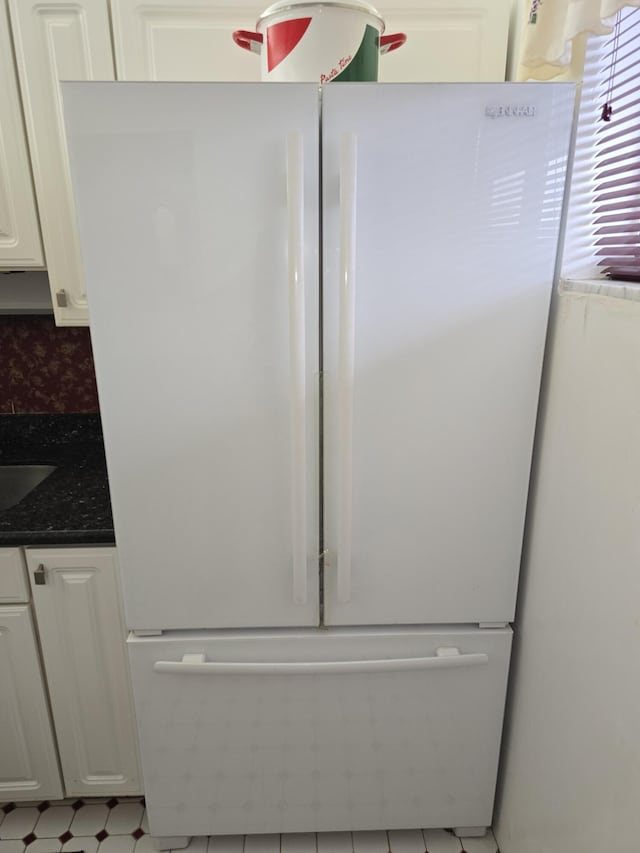 details with white cabinetry, white fridge, and tasteful backsplash