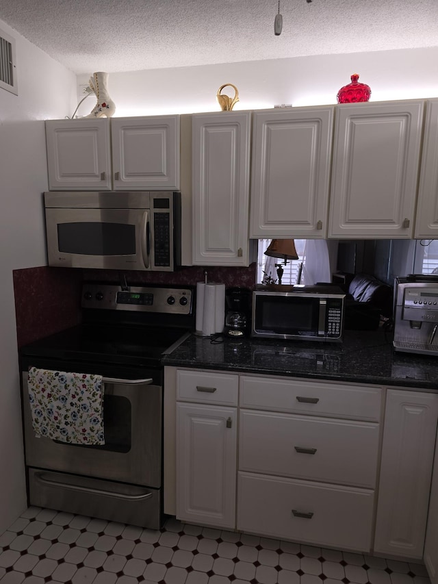 kitchen featuring white cabinets, a textured ceiling, and stainless steel appliances