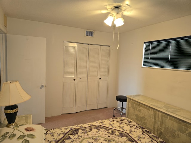 bedroom with ceiling fan, a closet, and light carpet