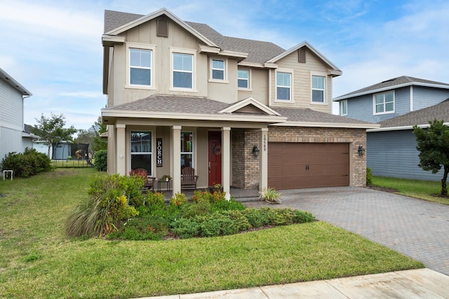 view of front of house with a garage, covered porch, and a front yard