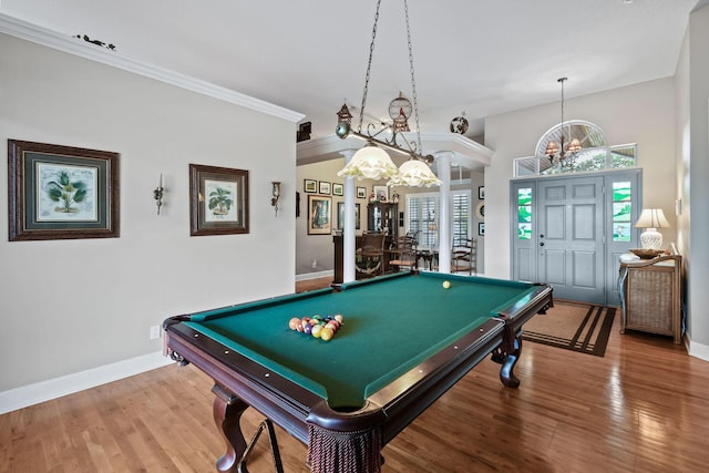 playroom featuring baseboards, crown molding, wood finished floors, and ornate columns