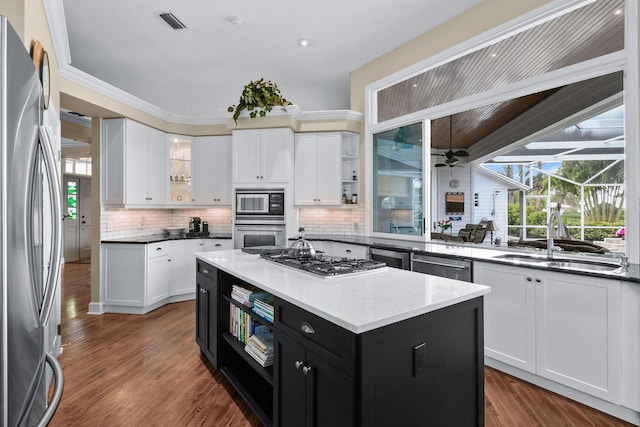 kitchen featuring stainless steel appliances, white cabinets, dark cabinetry, and a sink