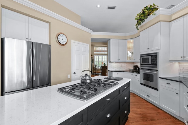 kitchen with white cabinetry, visible vents, stainless steel appliances, and dark cabinetry