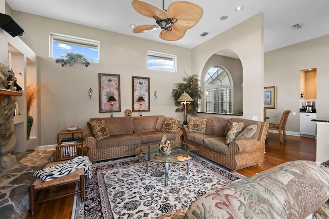 living room featuring baseboards, wood finished floors, visible vents, and a ceiling fan