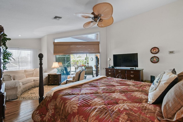 bedroom featuring visible vents, a sunroom, ceiling fan, wood finished floors, and access to exterior