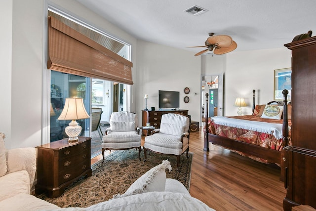 bedroom featuring ceiling fan, access to outside, wood finished floors, and visible vents