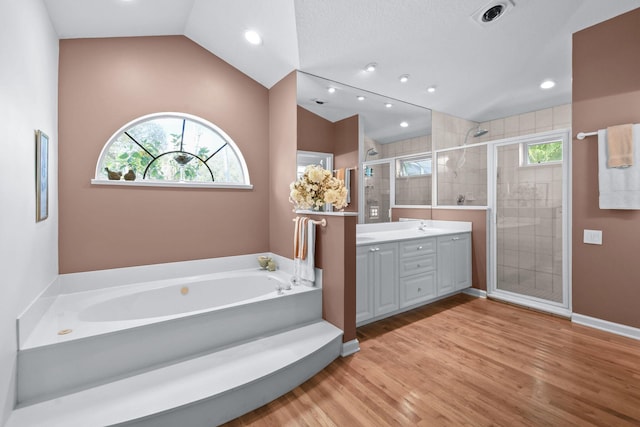 full bathroom with vaulted ceiling, double vanity, a stall shower, and a bath