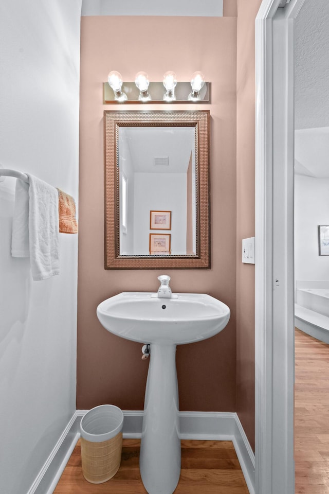 bathroom with wood finished floors, visible vents, and baseboards