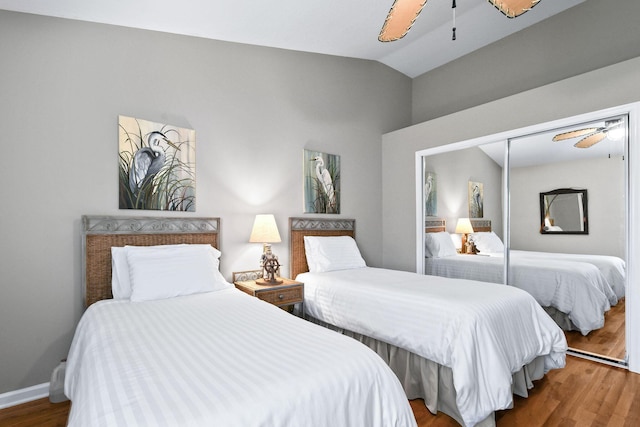 bedroom with lofted ceiling, a closet, ceiling fan, and wood finished floors